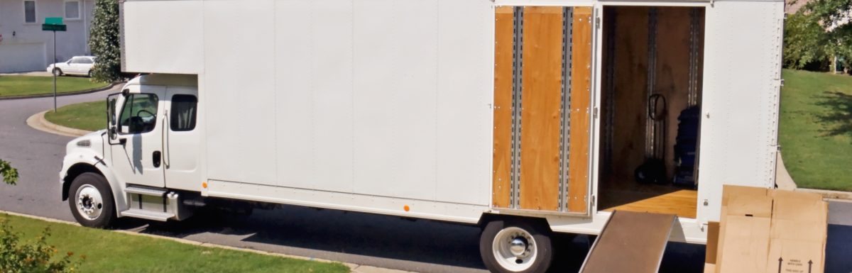 A white moving truck with a ramp set up in to the back