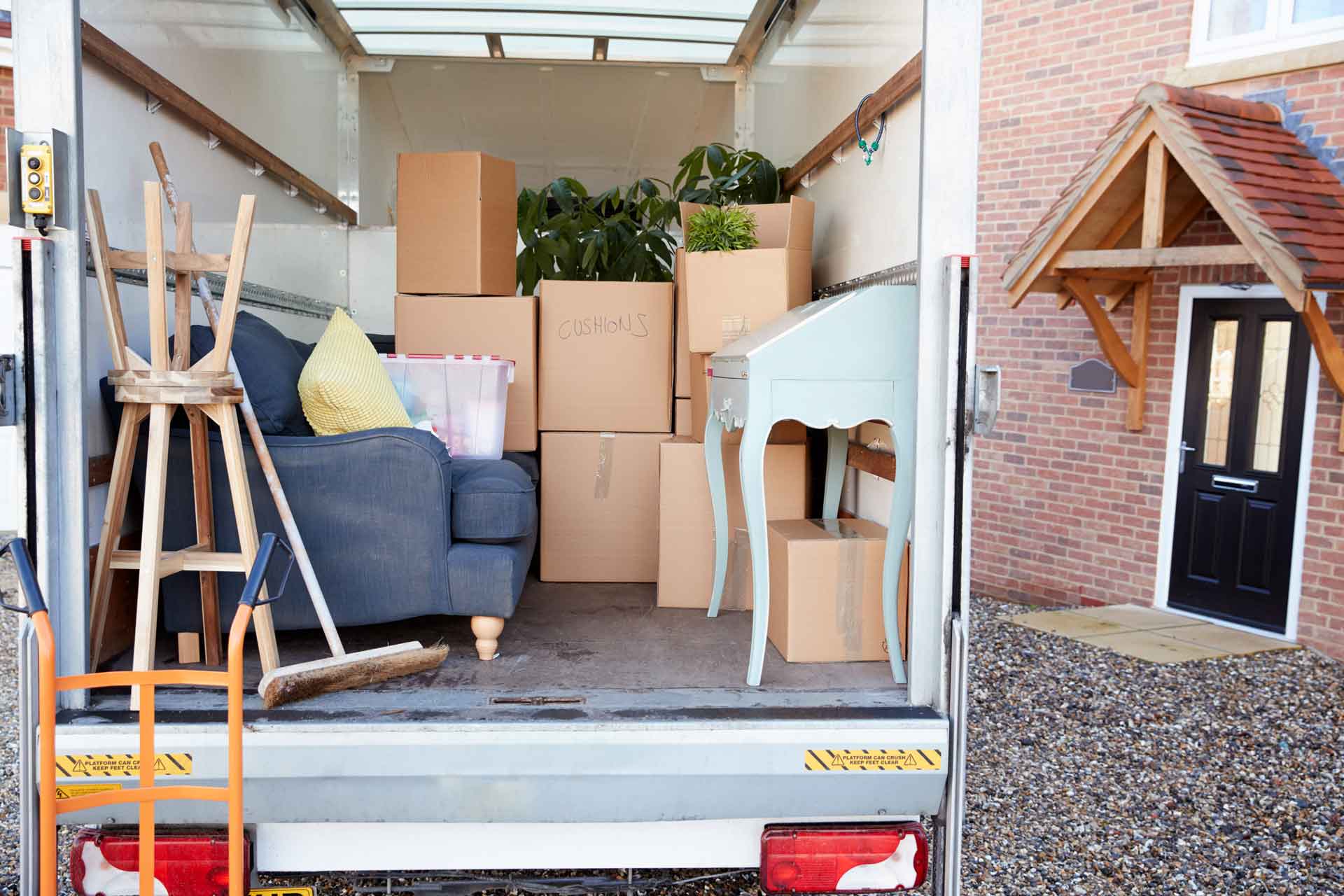 The back of a moving truck full of furniture and boxes